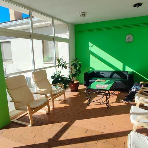 Sala de espera acristalada con butacas blancas